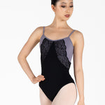 Ballet dancer wearing a black leotard with lace detailing on a white background