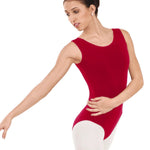 Woman wearing a red leotard and white tights on a white background
