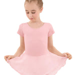 Young girl wearing a pink leotard with a skirt on a white background