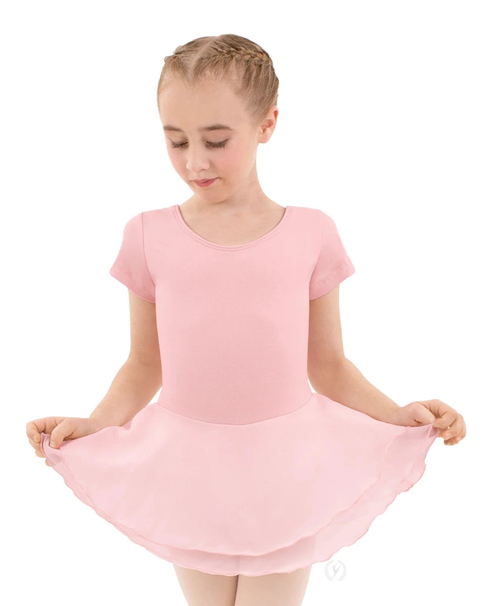 Young girl wearing a pink leotard with a skirt on a white background