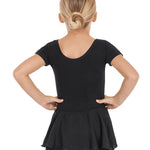 Young girl wearing a black dress with a sheer overlay on a white background