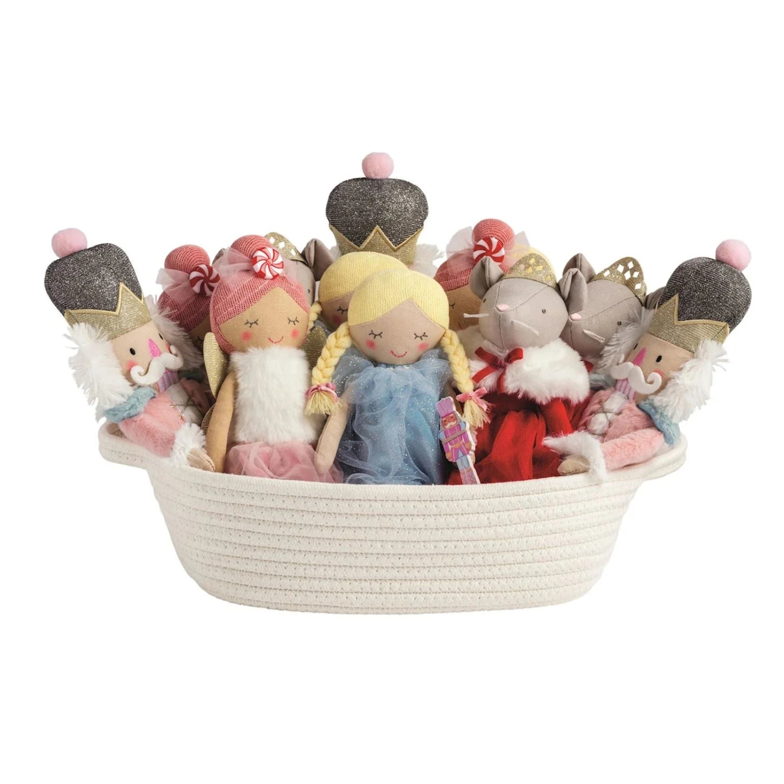 A set of five soft plush holiday toys arranged in a white woven basket on a solid white background. The toys include three nutcracker figures, a mouse, and a fairy, featuring soft pastel-colored clothing and gray glittery crowns.