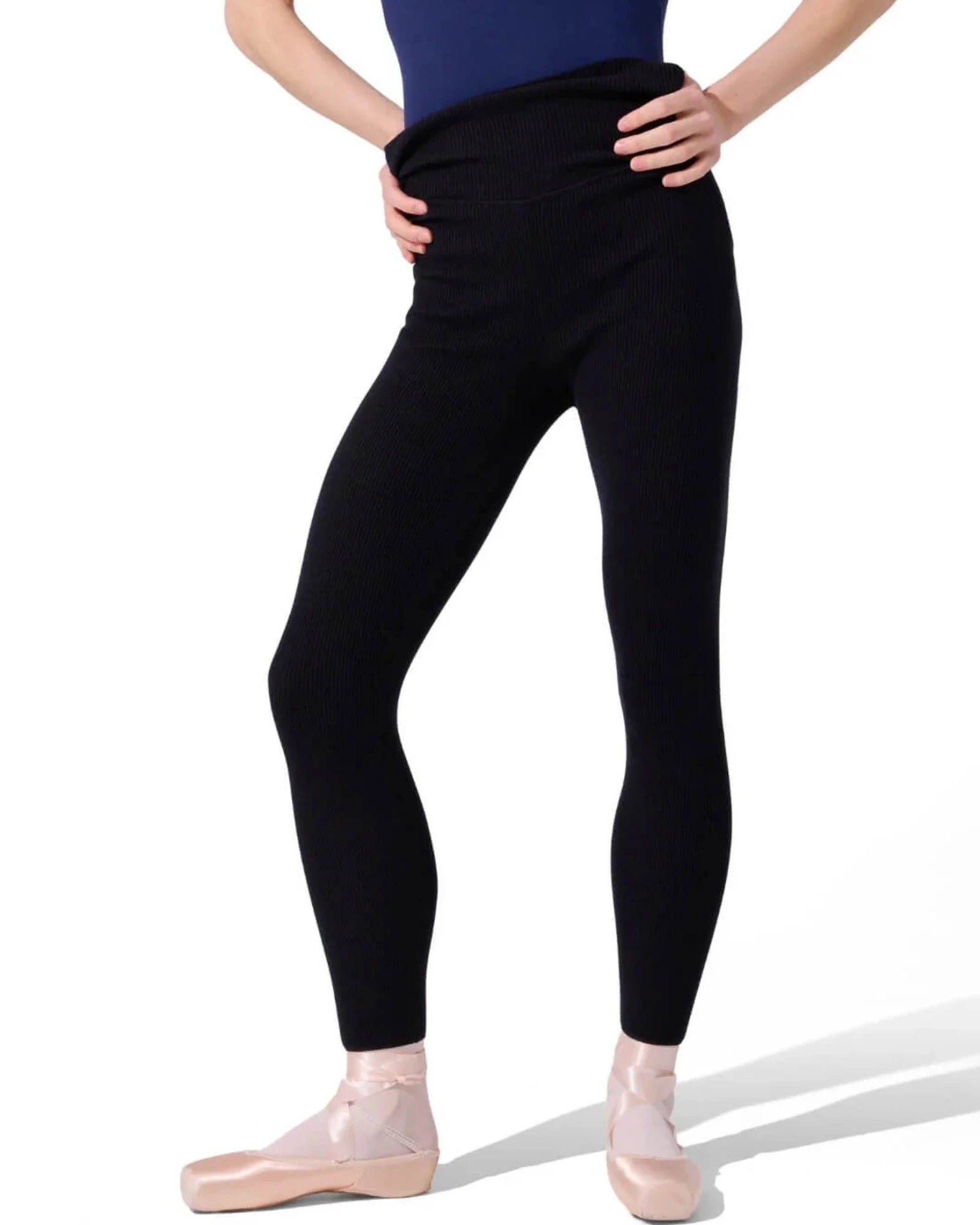 Person wearing black sweater tights and a blue leotard on a white background