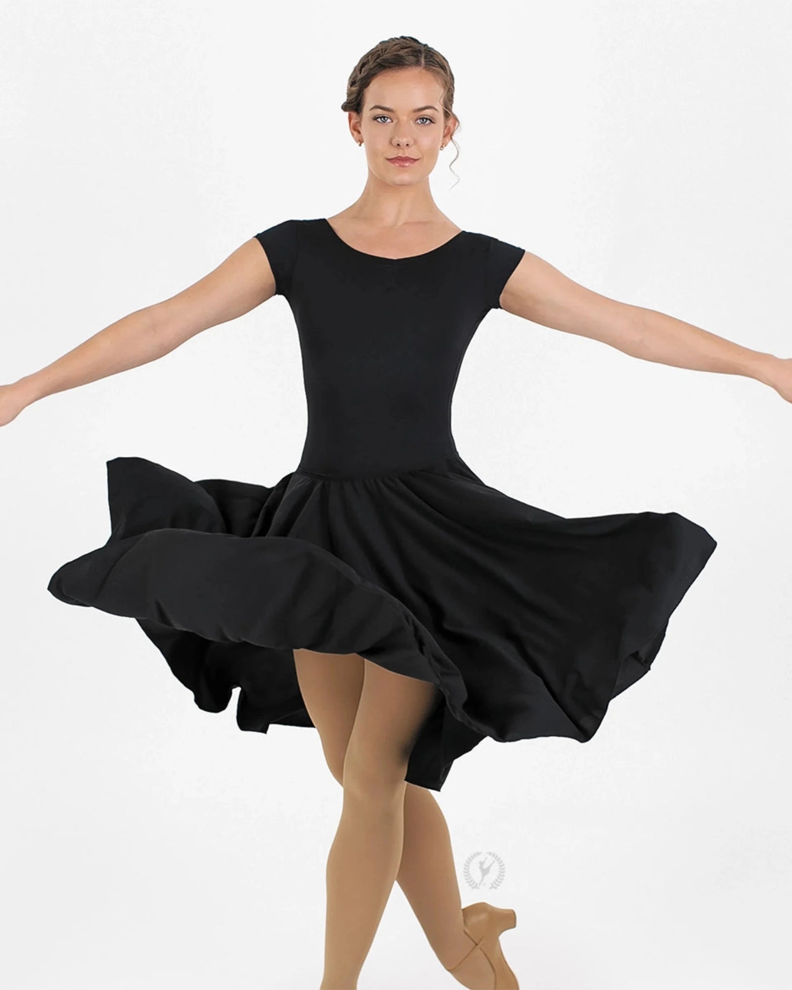 Dancer in a black dress with arms outstretched on a white background