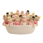 A collection of small plush ballerina dolls with pink and yellow dresses, sitting inside a cream-colored woven basket on a white background.