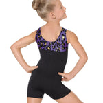 Girl wearing a black biketard with purple and gold leopard patterned top on a white background