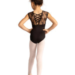 A young girl is shown from behind wearing a black lace leotard with criss-cross lace detailing on the back, paired with light pink tights and ballet shoes, set against a plain white background.