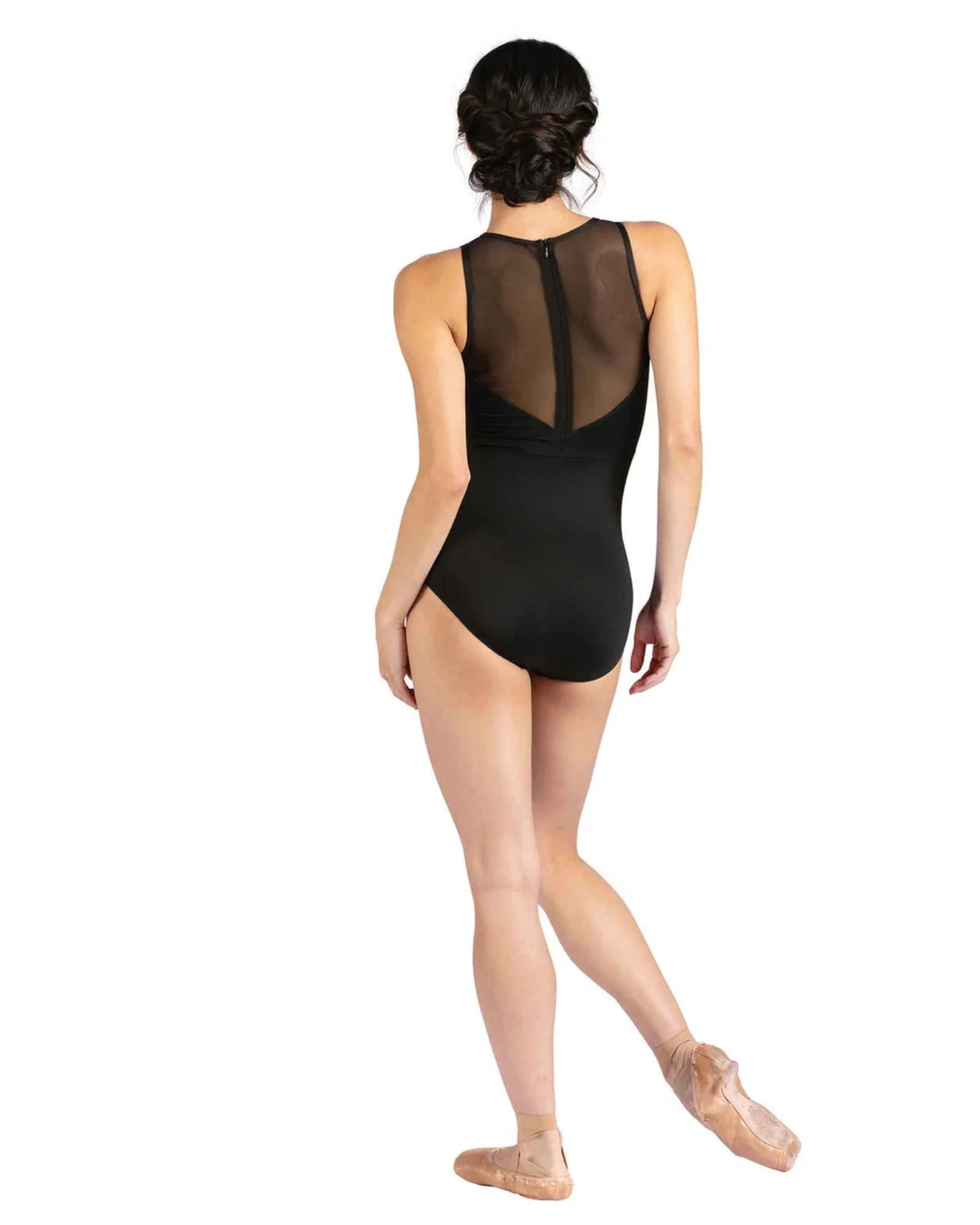 Person wearing a black leotard with sheer mesh panels on a white background