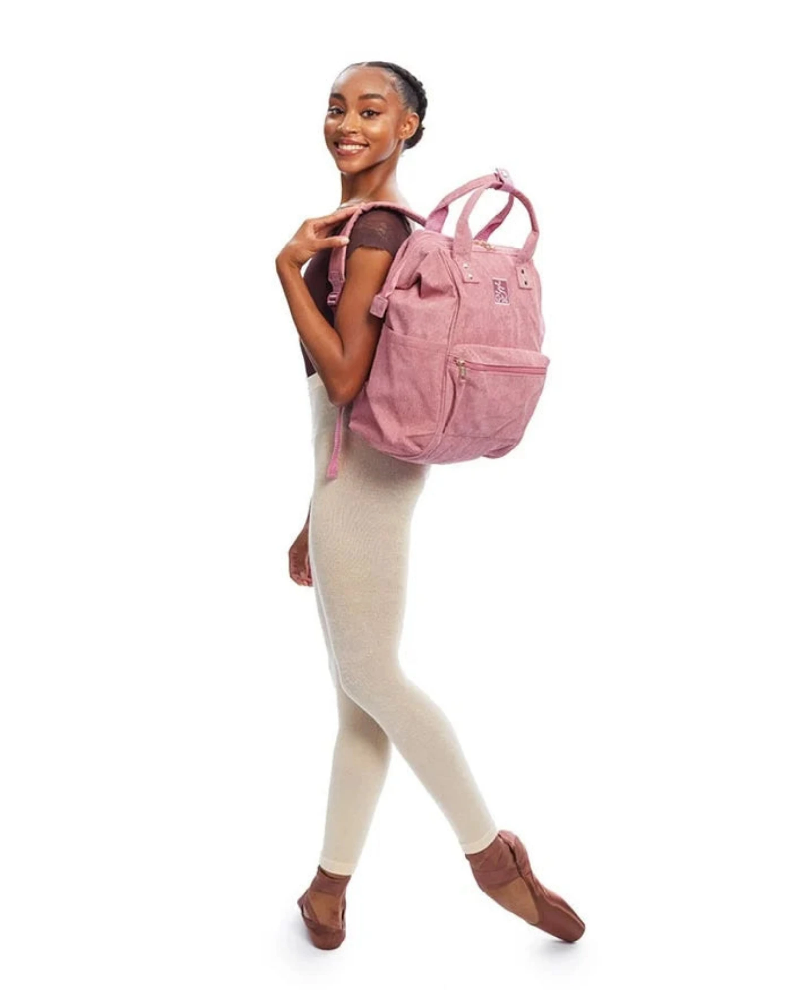 Woman wearing a pink corduroy backpack on a white background