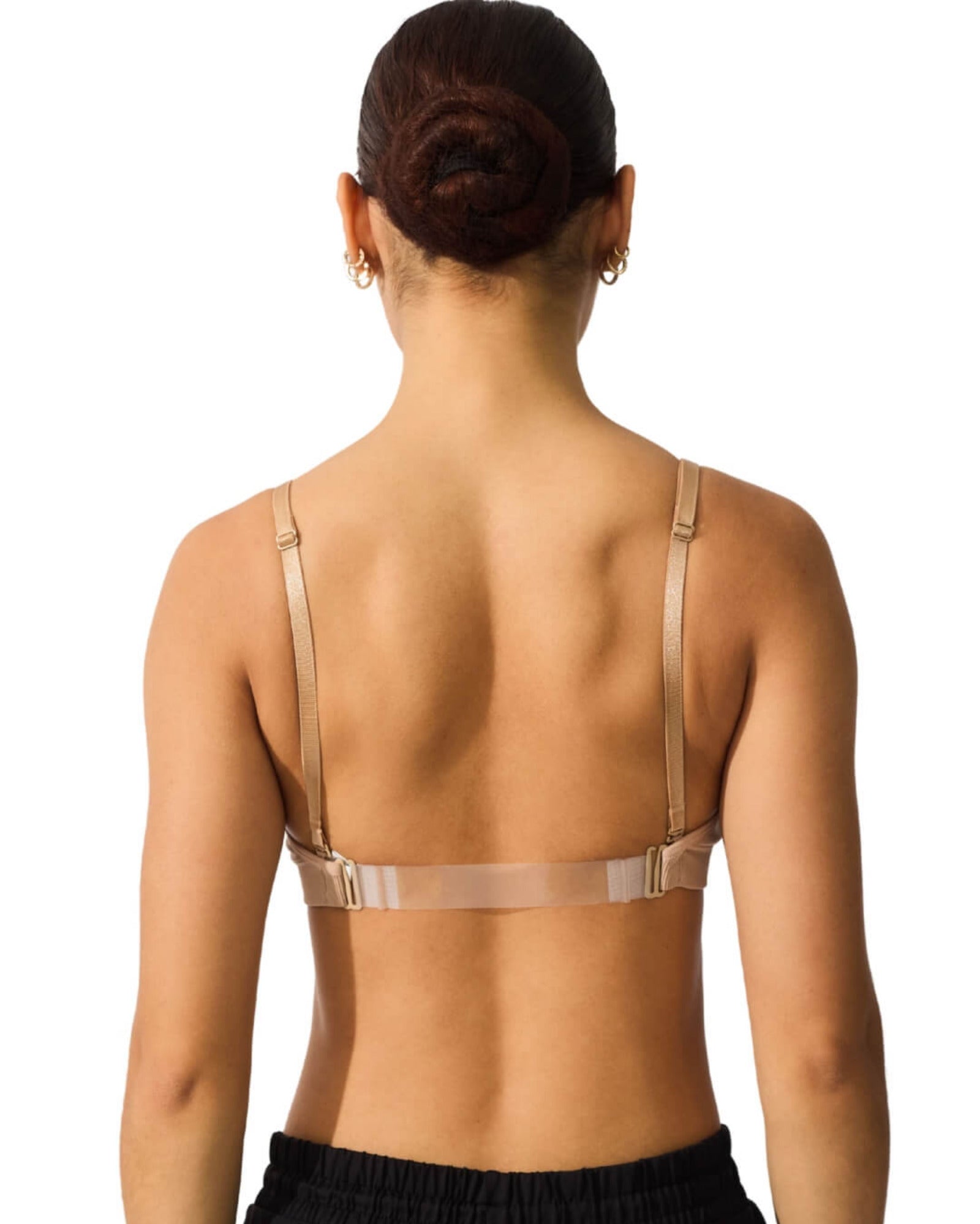 Woman wearing a beige bralette on a white background