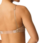 Beige bra worn by a person on a white background