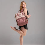 Woman posing with a pink backpack on a gray background