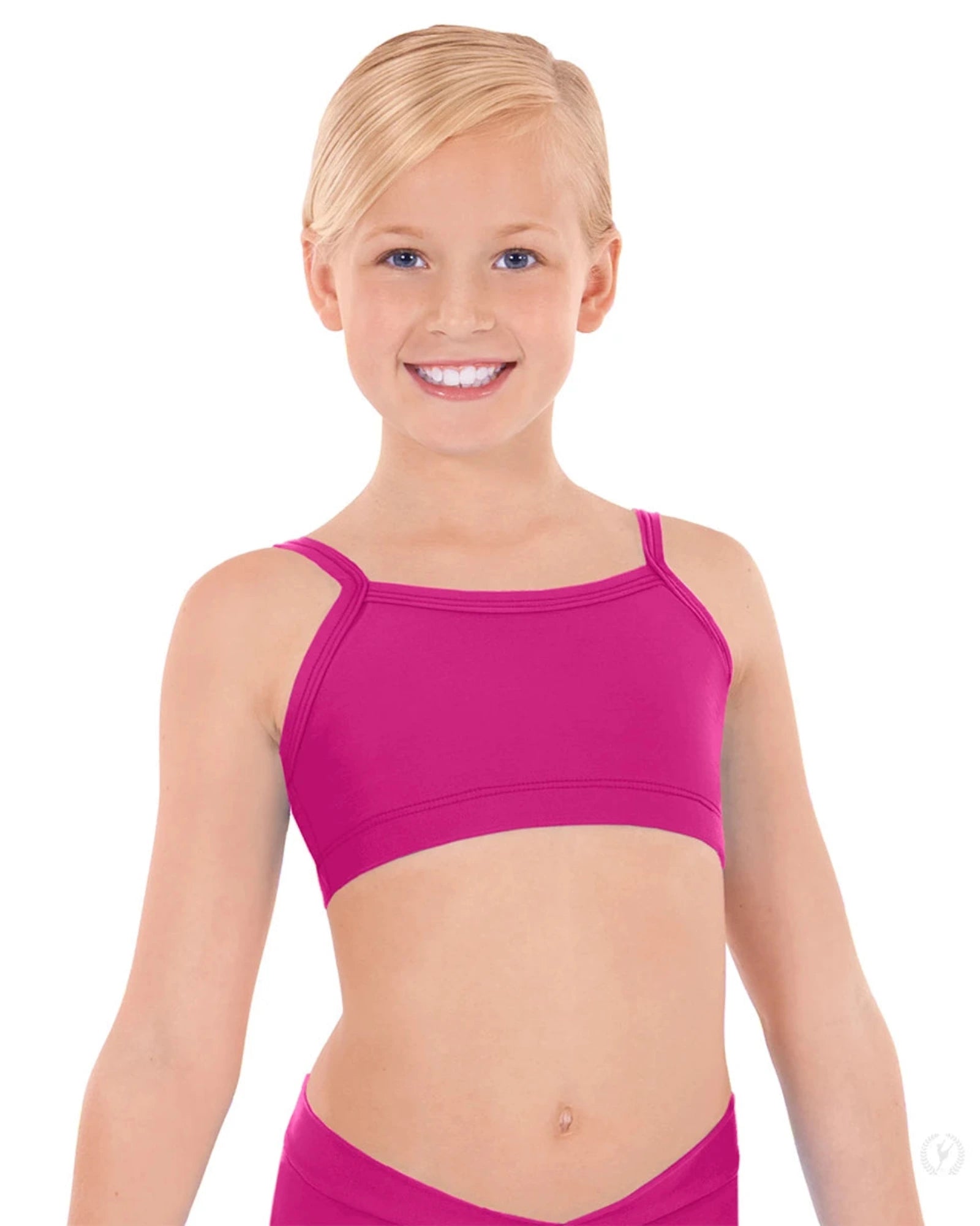 Young girl wearing a pink sports bra and shorts on a white background