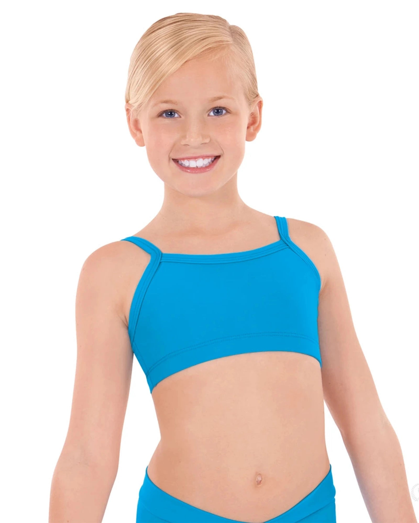 Young girl wearing a blue bra top and blue shorts on a white background