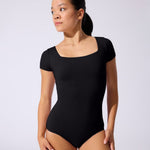 Woman wearing a black leotard against a white background