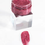 Pink glittery substance in a small jar on a white background