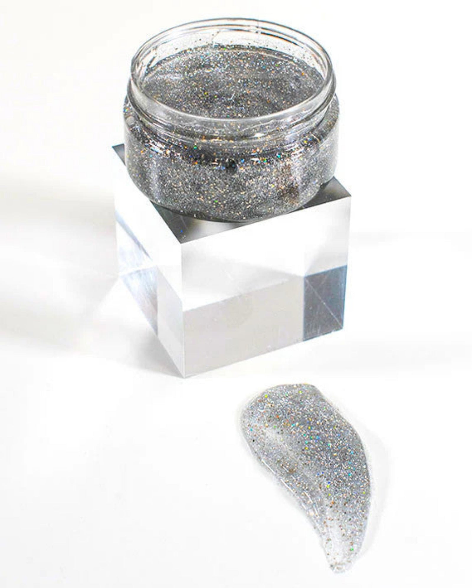 Silver glitter jar with a sample on a white background