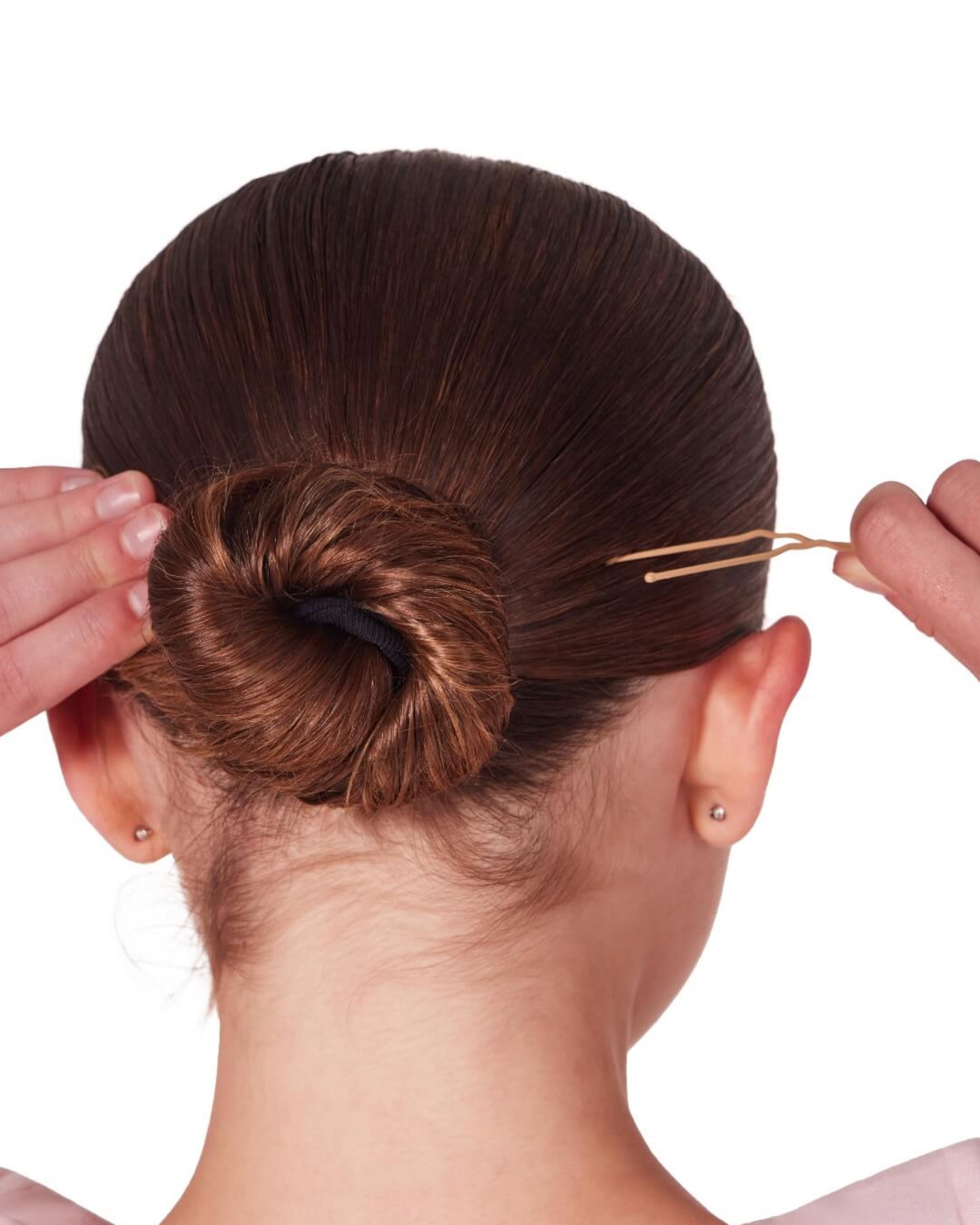 Person adjusting a hair bun with a hairpin on a white background