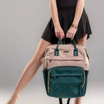 Person holding a beige and green backpack against a gray background