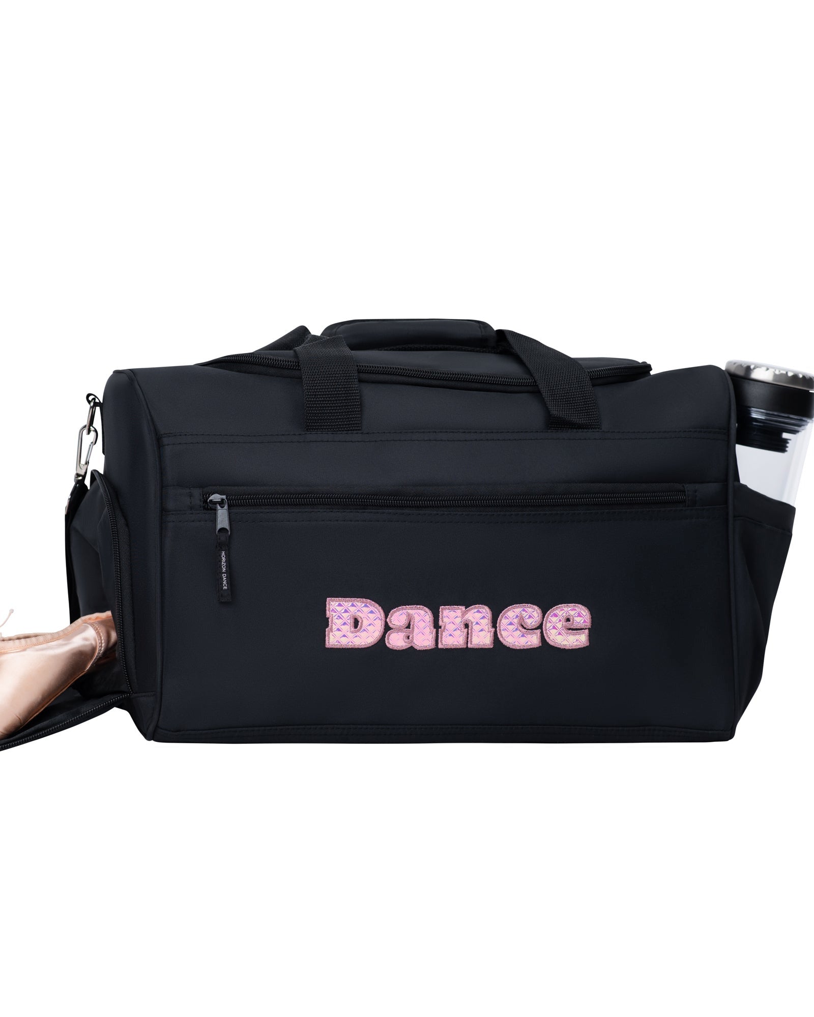 Black dance bag with 'Dance' written on it, next to a pair of pink ballet shoes on a white background.
