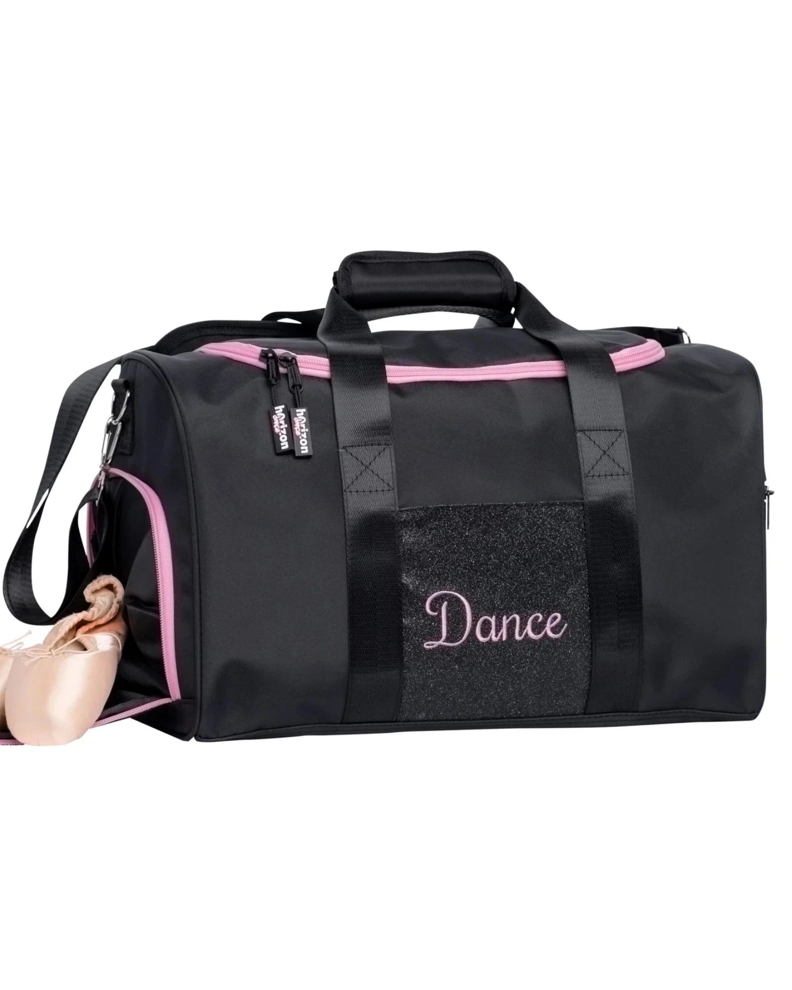 A black dance gym duffel bag with pink accents, featuring a glittery front pocket with 'Dance' embroidered in pink, a side zipper with pink lining, and a pair of pink ballet slippers tucked inside.