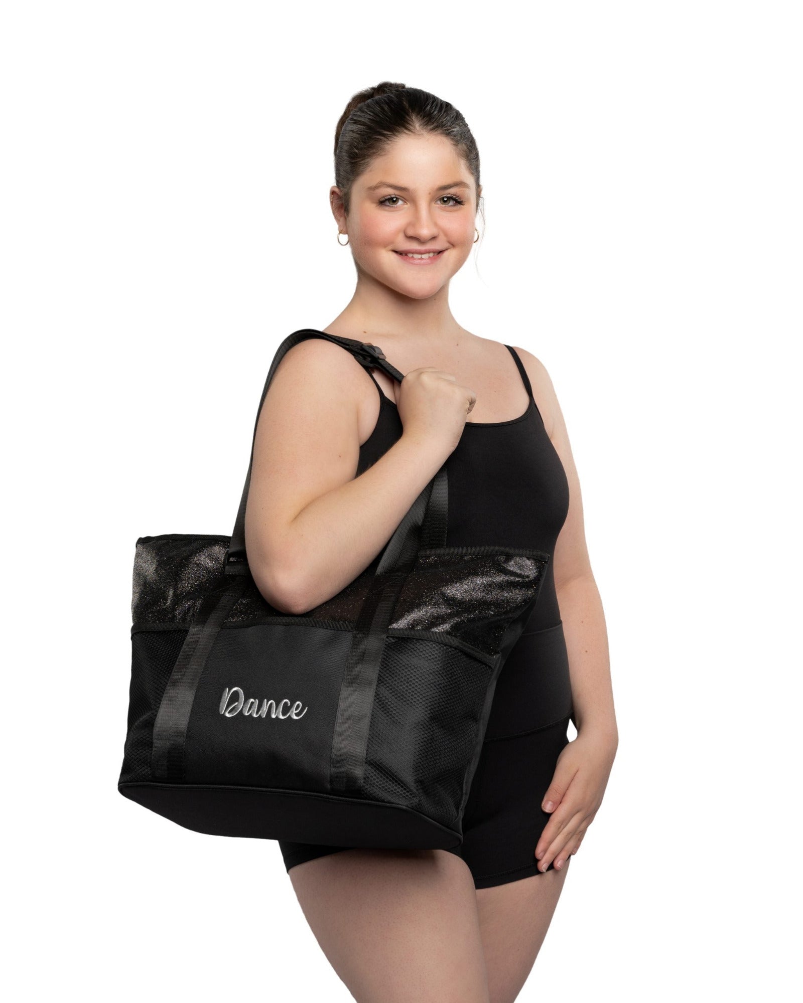 Woman holding a black tote bag with 'Dance' written on it against a white background