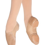 Beige jazz shoes worn with tights on a white background