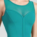 A close-up of a teal green sleeveless bodysuit or leotard with a sheer mesh V-neckline and structured corset-style front panels, shown on a model against a light gray background.