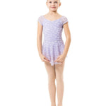 A young girl dancer standing in a light purple and white patterned leotard with matching tights and pink ballet slippers against a solid white background.