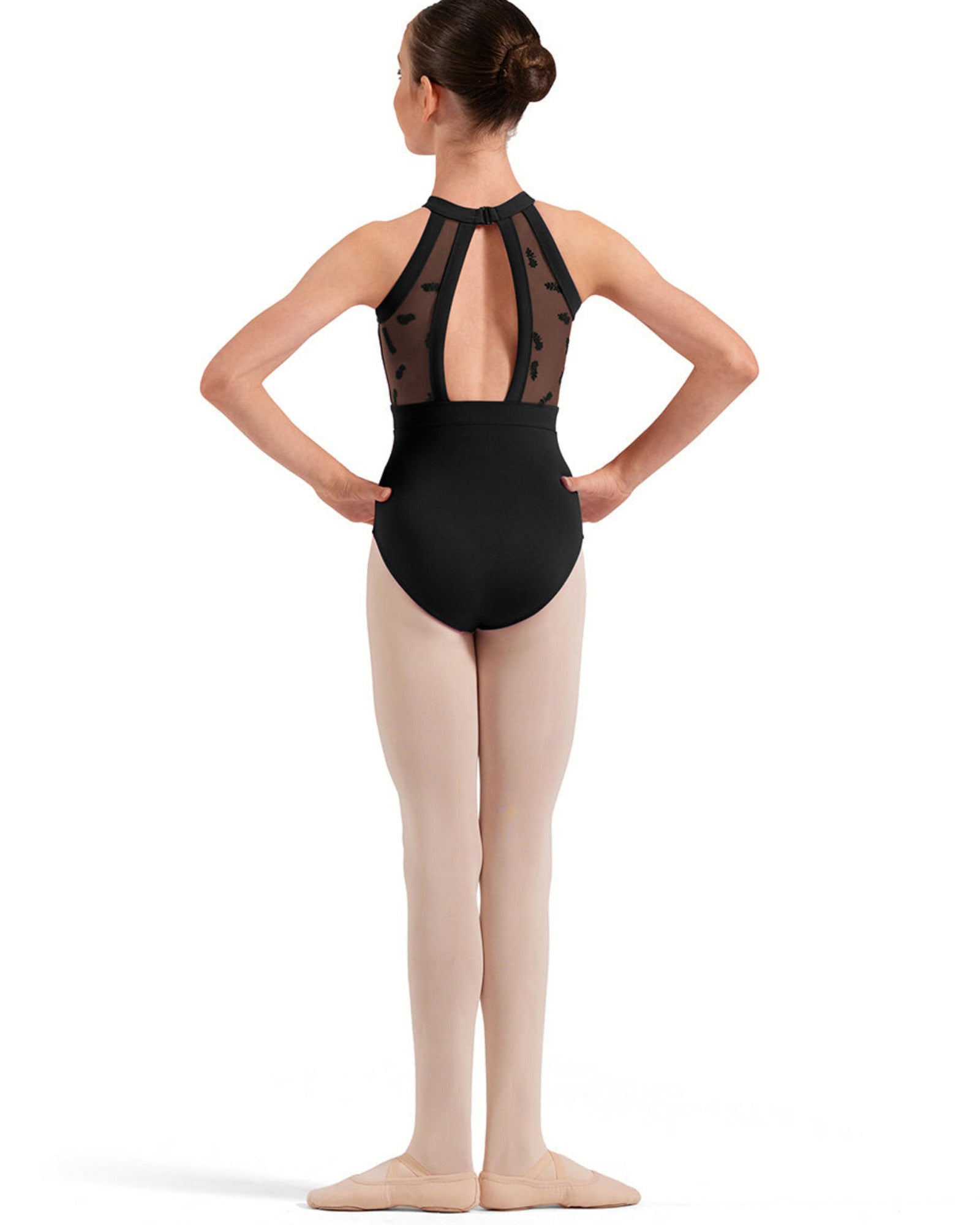 Ballerina in a black leotard with sheer details on a white background
