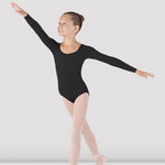 Ballerina in a black leotard and pink tights posing against a white background
