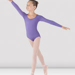 Ballerina in a purple leotard and pink tights posing on a white background