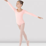 Ballerina in a pink leotard and tights posing against a plain background