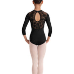 Ballet dancer wearing a black leotard with open back and pink tights on a white background