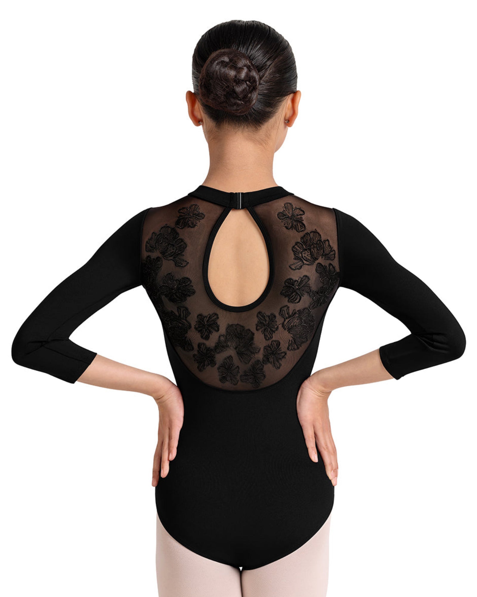 Ballerina wearing a black leotard with a flower print embroidered design on a white background