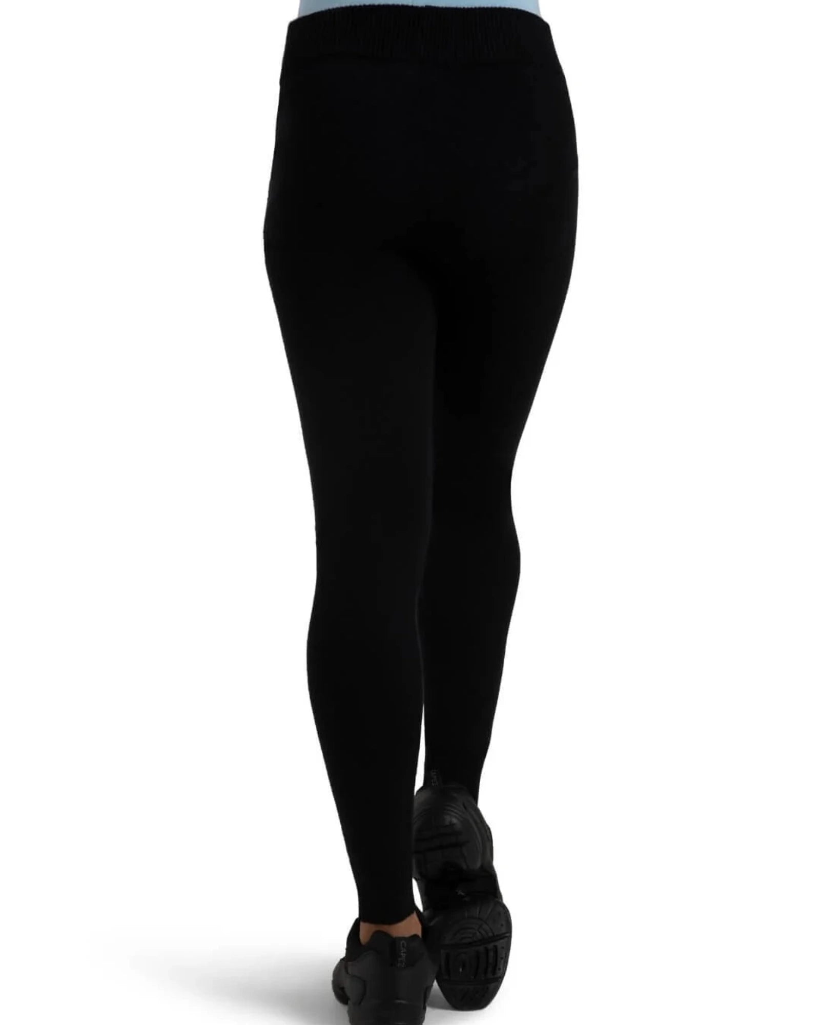 Black full-length knit leggings shown on a model from the back, paired with black sneakers against a plain white background.