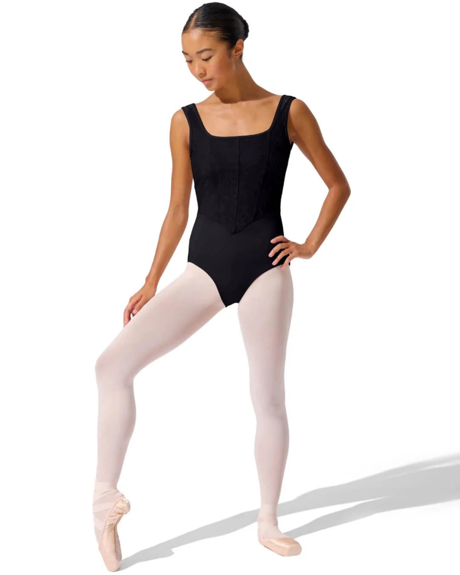 Dancer in a black leotard and pink tights on a white background