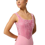 Ballerina wearing a pink leotard with lace details on a white background