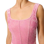 Close-up of a pink leotard with floral lace details on a white background