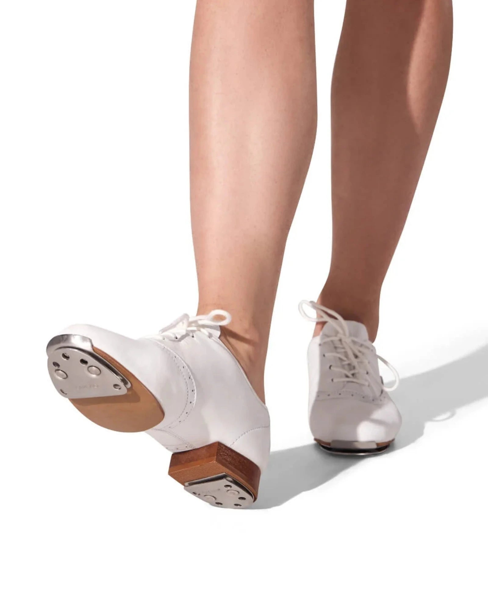 White tap shoes with wooden soles worn by a person on a white background