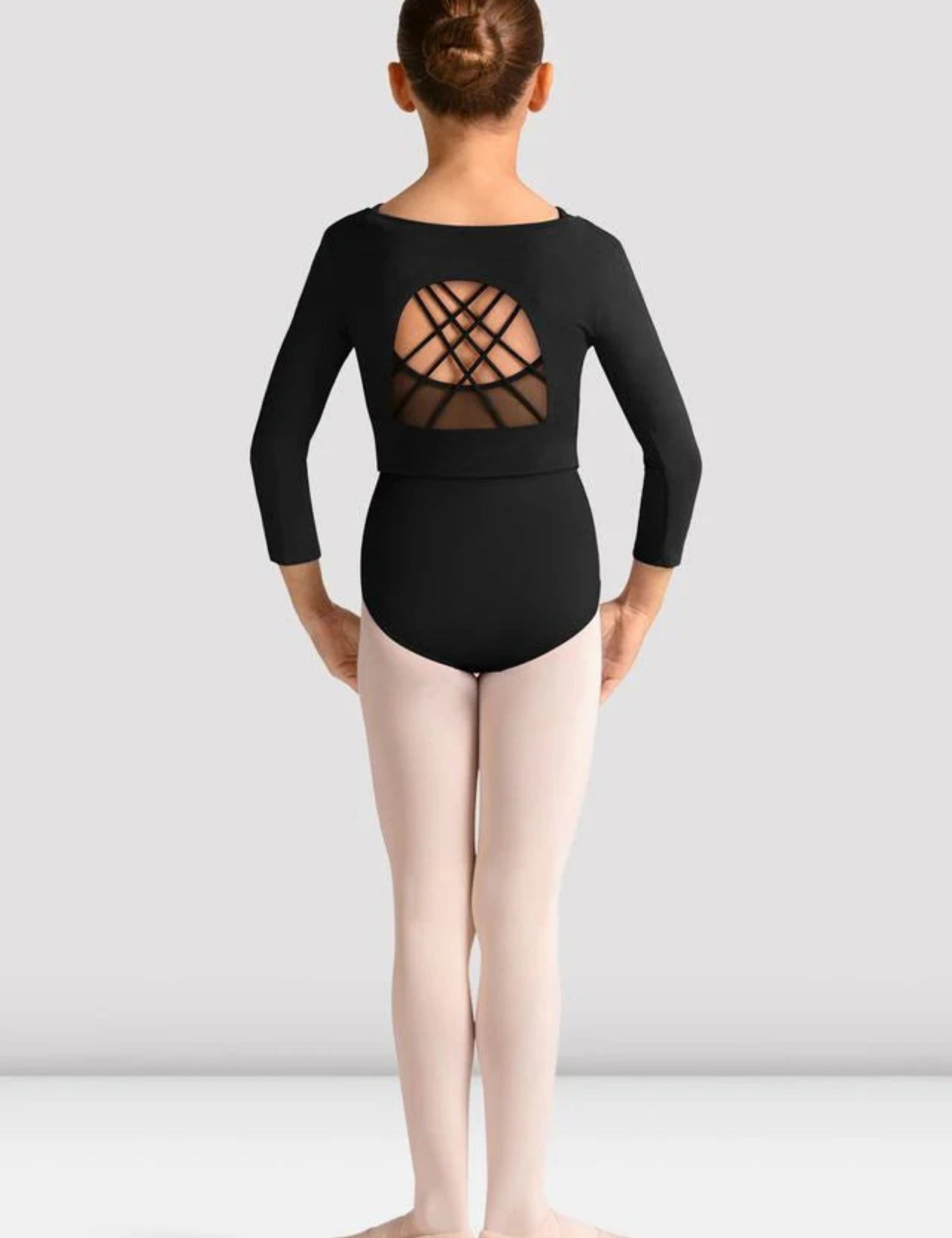 Young person wearing a black strappy open back crop top design on a plain background