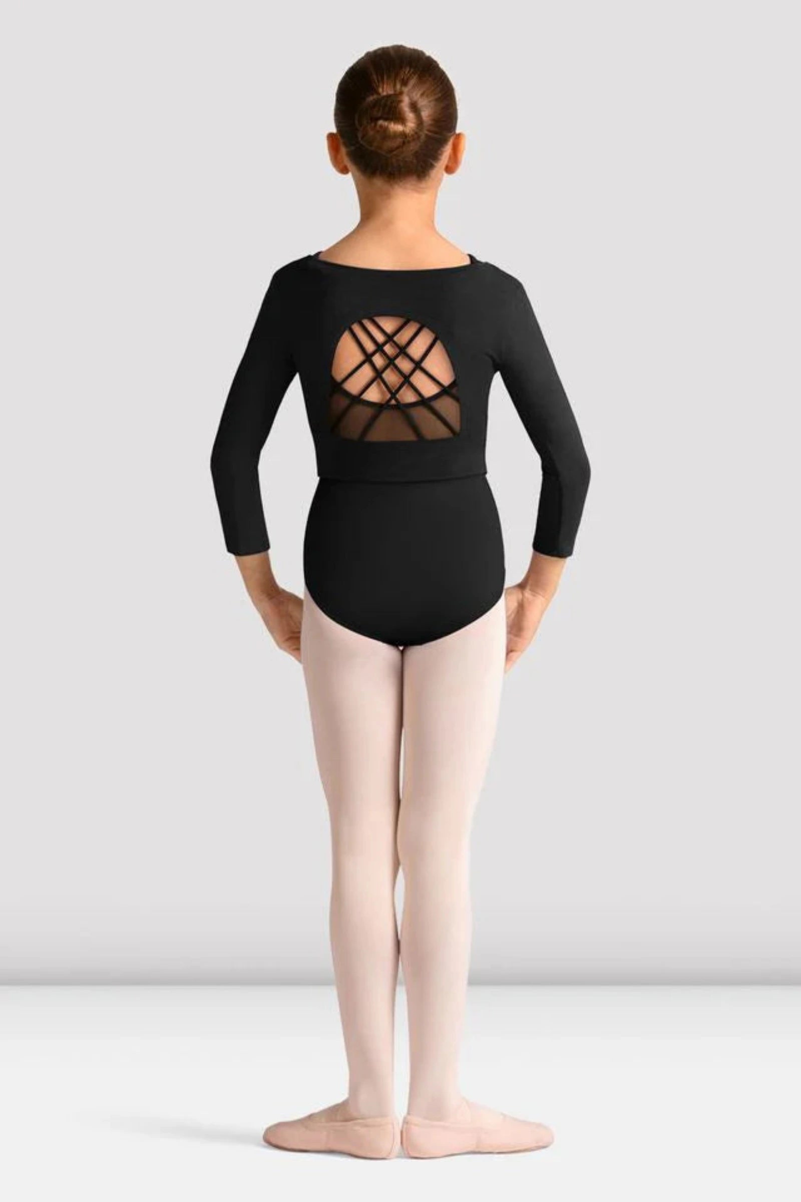 Young person wearing a black strappy open back crop top design on a plain background