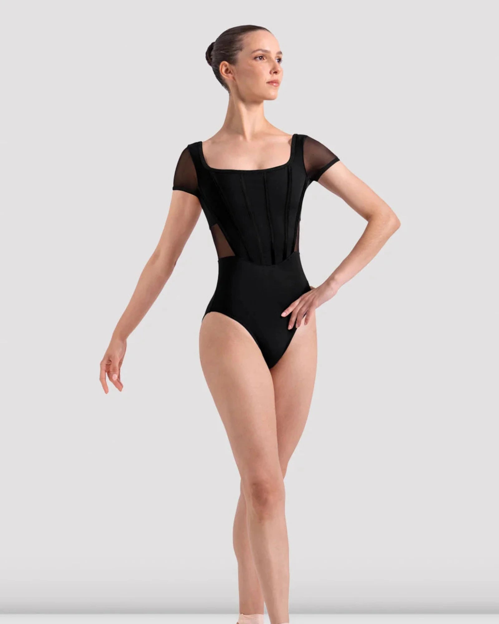 Ballerina in a black leotard on a white background