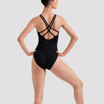Ballerina in a black leotard with criss-cross straps on a white background