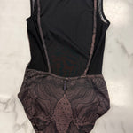 A sleeveless brown leotard with sheer mesh side panels and a brown floral lace overlay on the lower half, laid flat on a white marble surface.