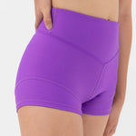Purple dance shorts worn by a person on a white background