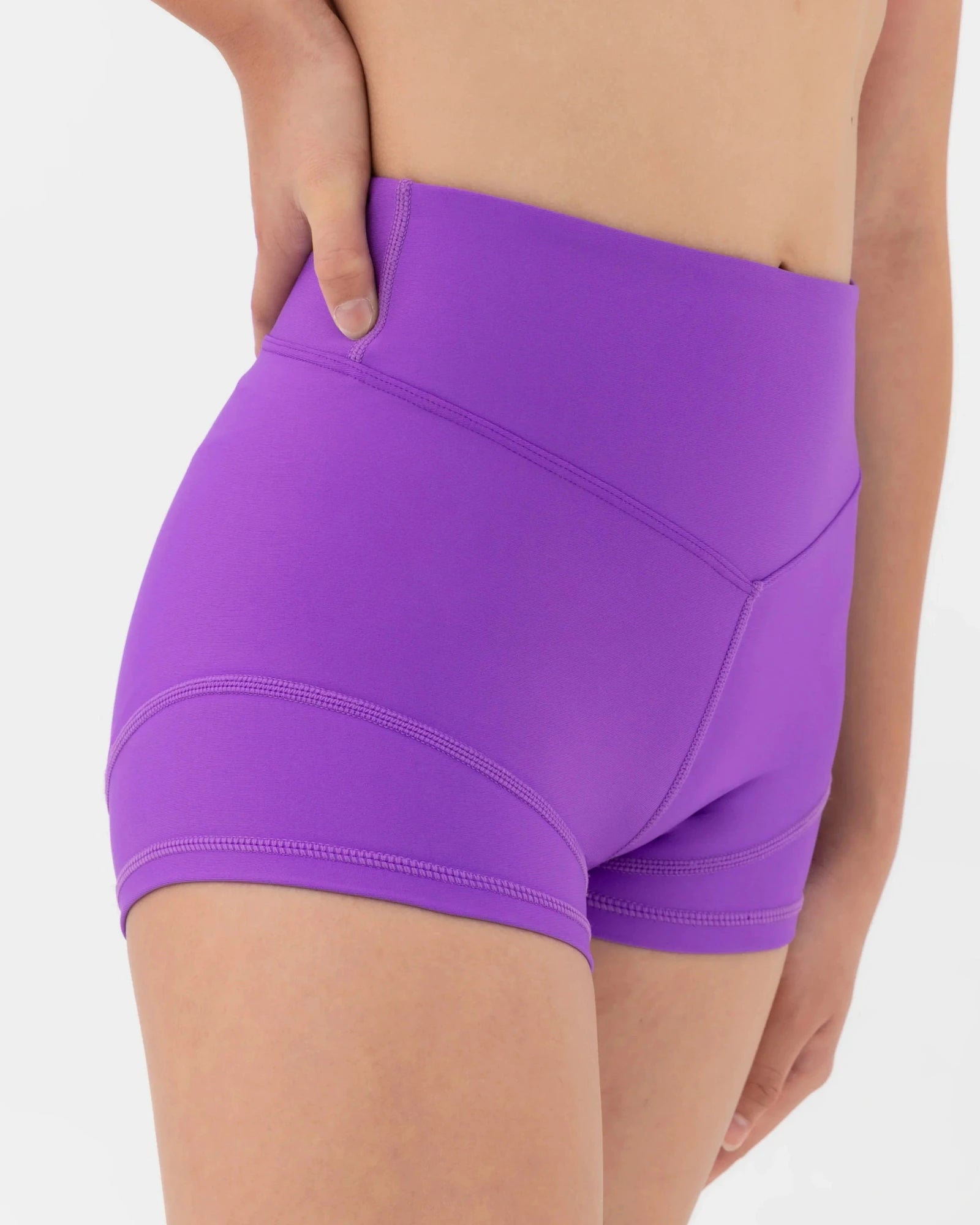 Purple dance shorts worn by a person on a white background