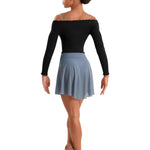 Dancer wearing a black top and blue skirt on a white background