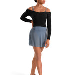 Woman wearing a black top and blue skirt on a white background
