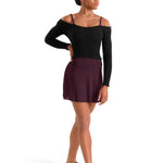 A woman modeling a black long-sleeve off-the-shoulder dance leotard top paired with a dark plum skirt, shown from the side against a plain white background.